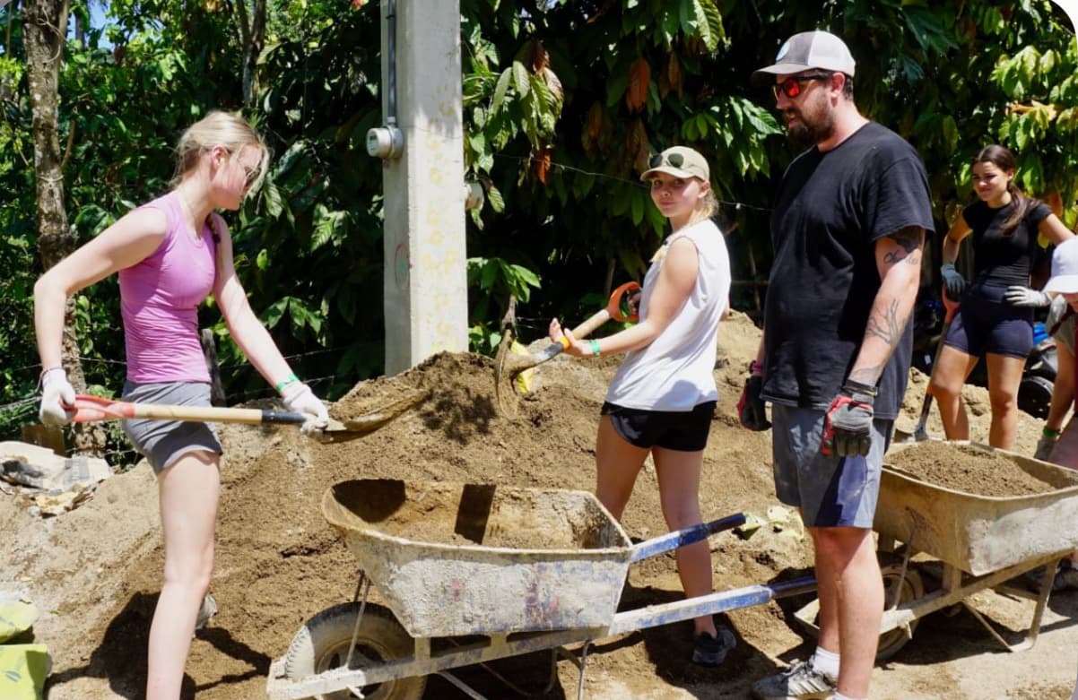 Volunteers and community members working together at a LiveDifferent build site in the Dominican Republic